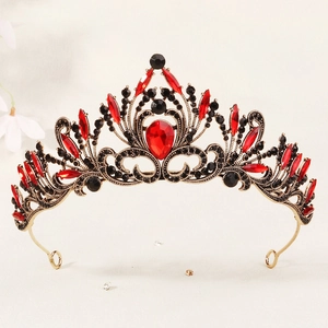 Close-up of vintage gold bridal crown with red pear-shaped crystals and black rhinestones