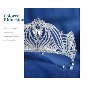 Macro shot of silver bridal crown with intricate rhinestones and pear-cut crystal center