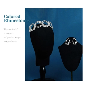 Detail view of bridal crystal tiara and teardrop earrings on black velvet stand