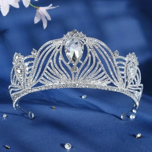 Luxurious silver bridal crown with crystals and drop-shaped gemstone on blue velvet