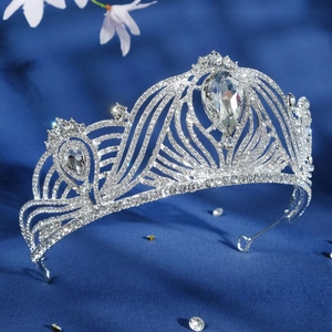 Elegant silver bridal crown with teardrop crystals and rhinestones on blue velvet background