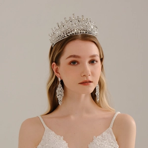 Luxurious bridal tiara set with crystal crown and leaf tassel earrings on grey background
