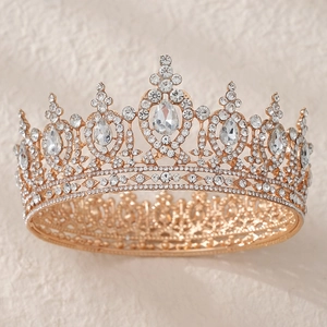 Close-up of golden bridal crown with sparkling AB rhinestones and large teardrop crystal