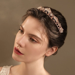 Détail d'une mariée portant un diadème en strass or rose avec des motifs ajourés élégants