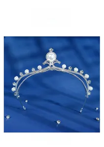 Detailed view of bridal tiara with rhinestones and white pearls on blue velvet