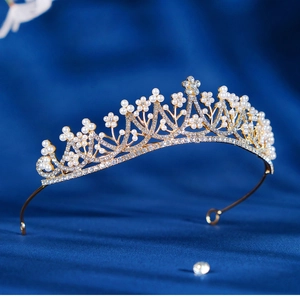 Elegant bridal crown with gold metal frame, white pearls and sparkling rhinestones