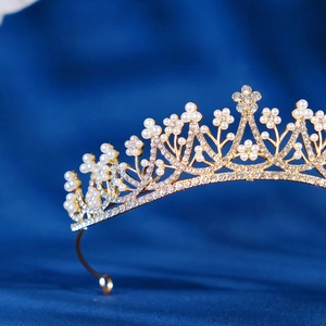 Luxurious bridal tiara crown with gold metal flowers, white pearls and sparkling rhinestones