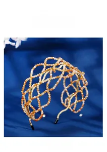 Close-up of peach and white crystal beads hand-woven on a gold mesh bridal headband