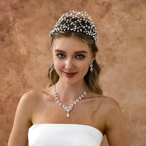 Detail of bridal hair net with white pearls and leaf necklace set for weddings