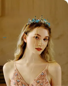 Detail of a vintage golden bridal crown with blue crystals worn by a model