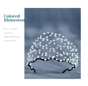 Detailed close-up of white pearls on silver wire mesh bridal headband with veil effect