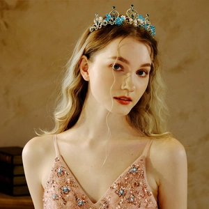 Baroque gold bridal tiara with blue sapphire crystals and pearls worn by a model