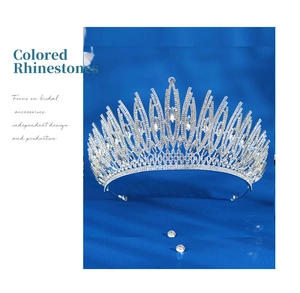 Detail shot of luxury silver bridal tiara with intricate rhinestones on dark blue velvet