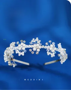 Detailed macro view of handmade bridal headband with woven white pearls and crystal flowers