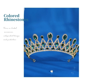 Detail of luxury bridal crown featuring emerald green crystals and golden alloy setting