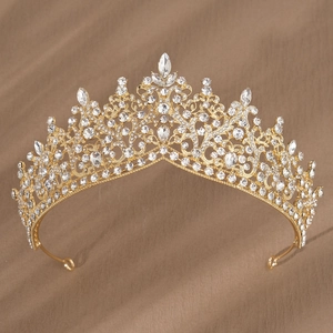 Détail d'une couronne de mariée dorée ornée de cristaux rouges et de strass brillants