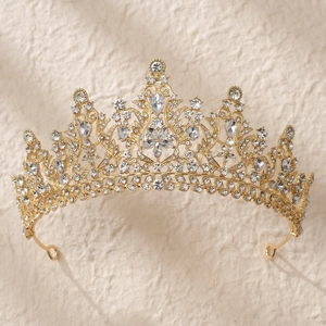 Gros plan d'une couronne de mariée dorée avec des strass étincelants sur fond beige