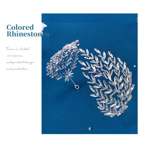 Close-up of silver bridal headband with sparkling rhinestone leaves on blue background