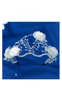 Gros plan d'un serre-tête de mariée avec fleurs en tissu blanc et perles en cristal