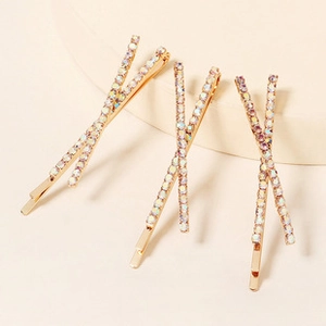 Detail showing gold plated criss-cross hair clips with shimmering colorful rhinestones