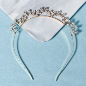 Elegant gold metal headband with sparkling rhinestones on a marble background