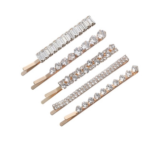 Detail of five gold crystal hair clips with different rhinestone cuts and settings