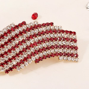 Macro shot of red and white crystals in wave pattern on a gold hair clip