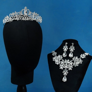 Detail of bridal jewelry set with silver crown and crystal teardrop necklace and earrings