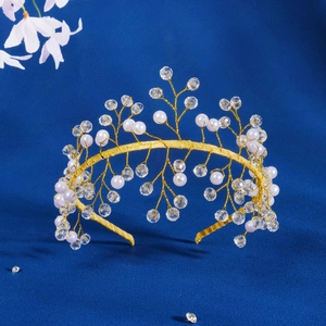Close-up of handmade gold wire headband with white pearls and clear crystals