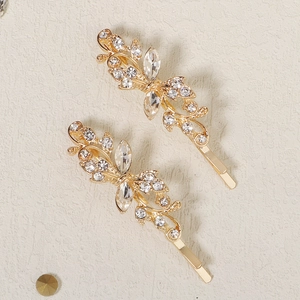 Close-up of golden leaf and flower hair clips with sparkling crystal rhinestones set of 2