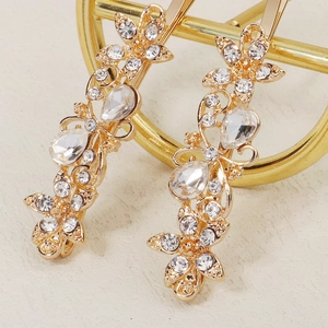 Close-up of golden floral hair clips with sparkling rhinestones and crystal details