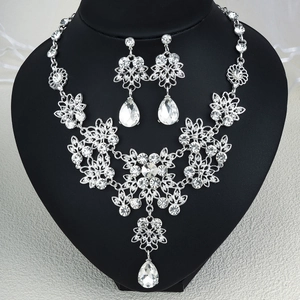 Exquisite bridal jewelry set with sparkling crystals and teardrop pendants on a black stand