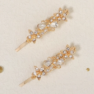 Macro view of gold flower and butterfly hair clips with sparkling crystal rhinestones