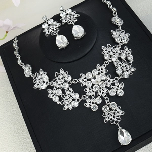 Macro detail of luxury bridal jewelry set with sparkling pear-cut crystals on black display