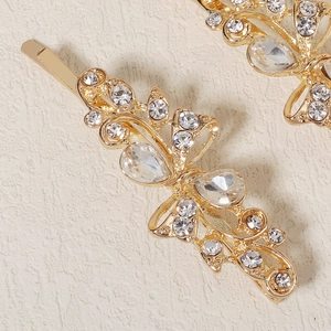 Macro shot of gold butterfly hair clip with sparkling crystal wing details on metal base