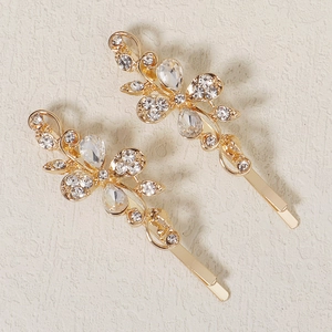 Detailed view of two gold floral butterfly hairpins with sparkling crystal rhinestones