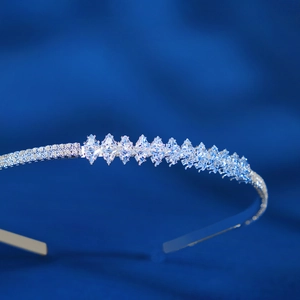 Gros plan du serre-tête argenté avec zircons marquise sur fond velours bleu
