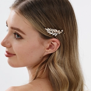 Elegant gold leaf hair clip with marquise rhinestones worn by a model in soft light