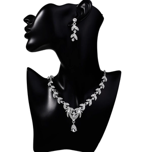 Detailed view of silver leaf-style necklace and earrings set with zircon accents