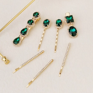 Detail of 7-piece hair clip set with emerald faux gemstones and gold-plated alloy finish