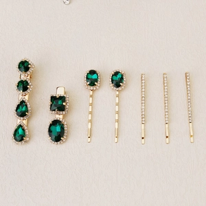 Detail of 7-piece hair clip set with emerald green gems and gold plating