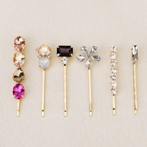 Detail of 6-piece gold hair clip set featuring colorful crystal flowers and rhinestones