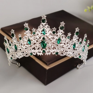 Close-up of luxury bridal tiara with emerald green stones and sparkling white crystals