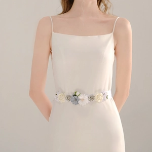 Detail of handmade bridal sash with blue and white fabric flowers and crystal centers