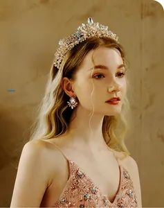 Detail shot of bridal crystal crown and matching floral rhinestone earrings in rose gold