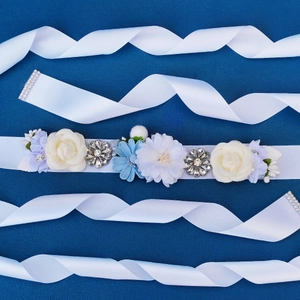 Detailed close-up of handmade bridal sash with silk roses and sparkling rhinestones