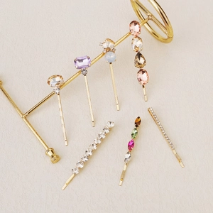 Detail view of colorful rhinestones and gold alloy clips on a metal display rack