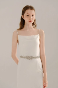 Close-up of sparkling bridal dress belt featuring floral rhinestone clusters on silver base
