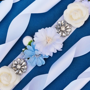 Detailed view of handmade bridal belt with blue fabric flowers and silver rhinestones