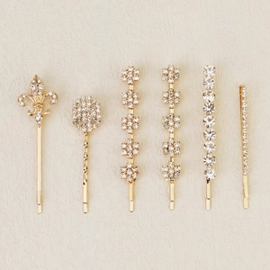Detailed macro shot of six gold-plated hairpins set featuring fleur-de-lis and rhinestones